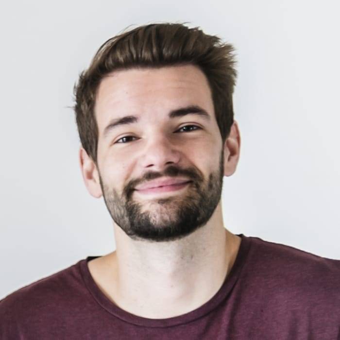 Smiling young man with a beard wearing a maroon shirt, representing satisfied customer experience with OMY Locksmith services.