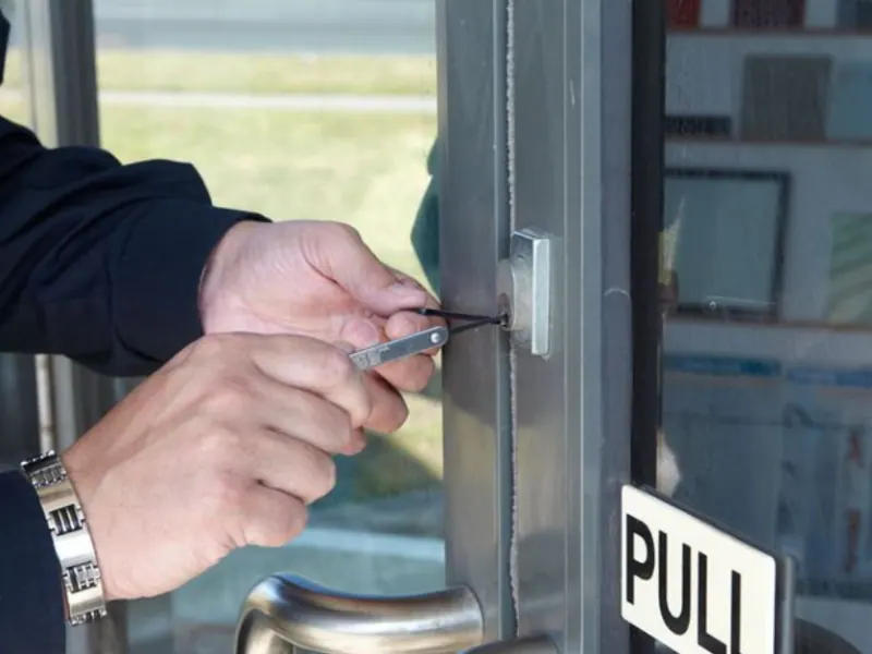 Locksmith using a tool to unlock a door, highlighting commercial lockout services for businesses.