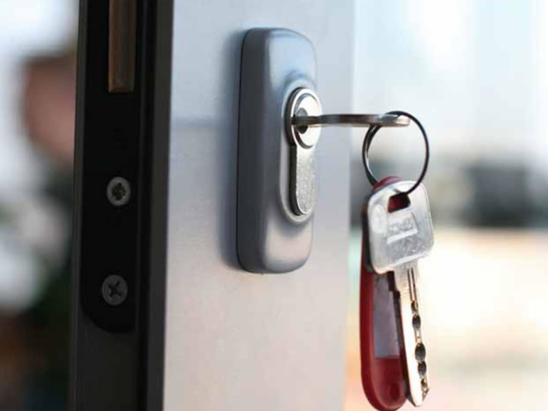Key inserted in a lock with additional keys on a keyring, illustrating access control and security solutions for commercial and residential properties.
