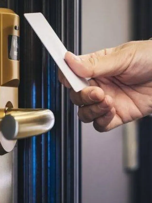 Hand using a key card to unlock a door, representing modern locksmith solutions and access control services.