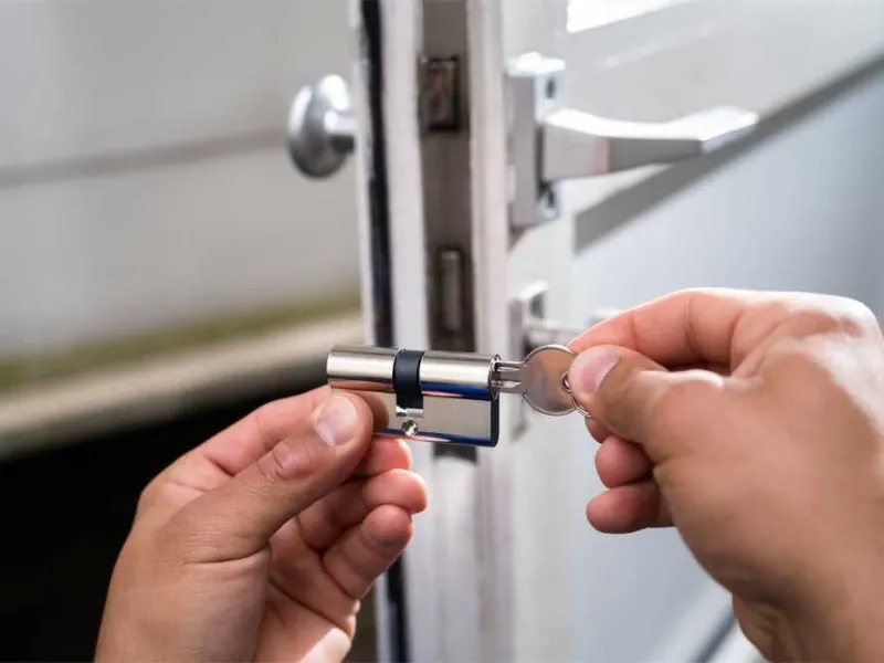 Person inserting a key into a door lock, demonstrating locksmith services for residential security in Columbia, MO.